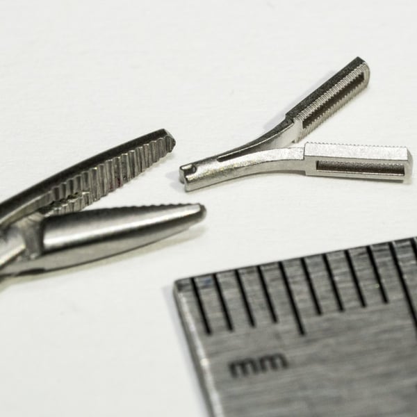 Serrated micro jaw, beside a hemostat
