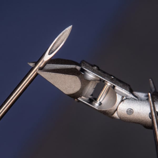 Articulated grasper beside a needle